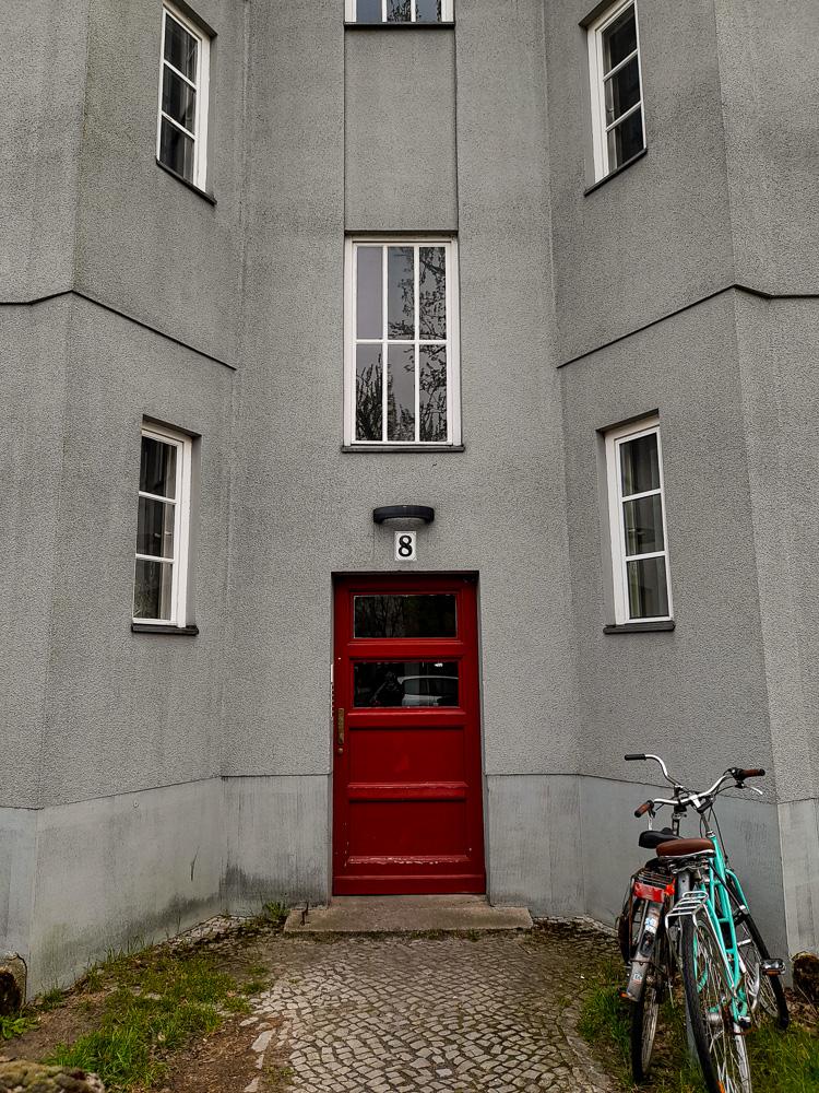 Foto des Eingangs eines grauen Hauses in der Berliner Splanemannsiedlung,